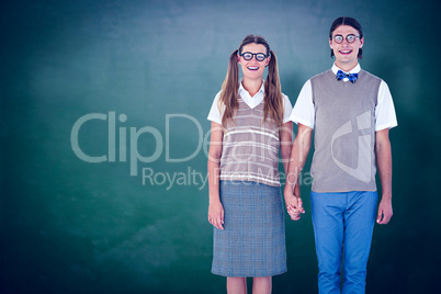 Composite image of geeky hipster couple holding hands