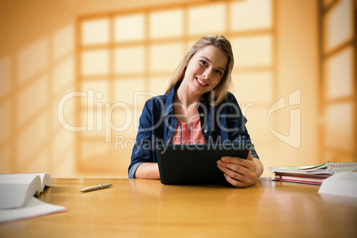 Composite image of student studying in the library with tablet