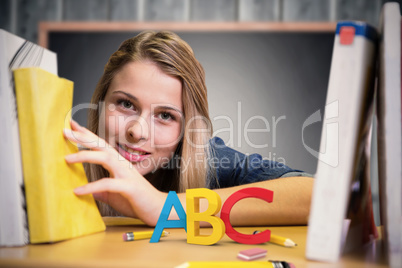 Composite image of pretty student in the library