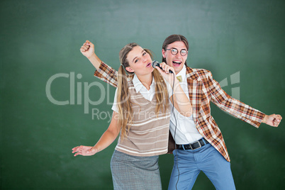 Composite image of happy geeky hipsters singing with microphone