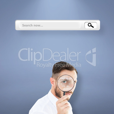 Composite image of geeky businessman looking through magnifying