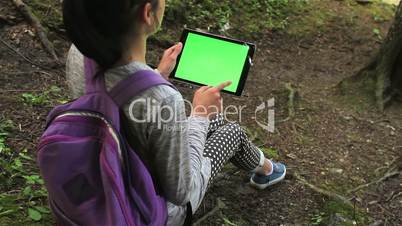 Teenage girl using tablet pc with green screen