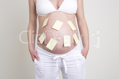 Pregnant woman with lots of yellow labels on her belly