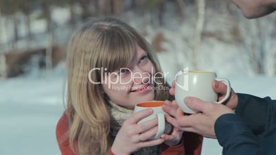 Young couple in love on a winter vacation enjoying the nature and drinking hot tea