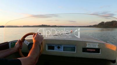 Man in a motor boat cruising at the lake