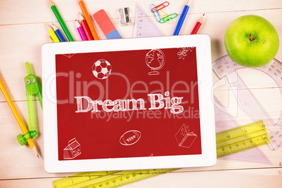 Dream big against students desk with tablet pc