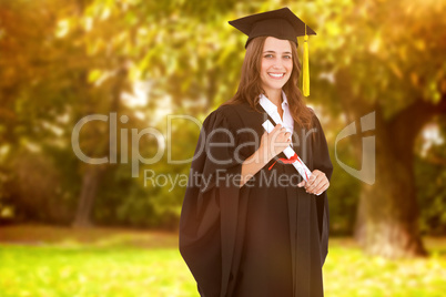 Composite image of a smiling woman with her degree as she looks