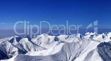 Panoramic view on off-piste slopes and multicolor blue sky at ni