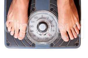 Feet on a bathroom scale isolated on white. Woman on diet steped on scale.