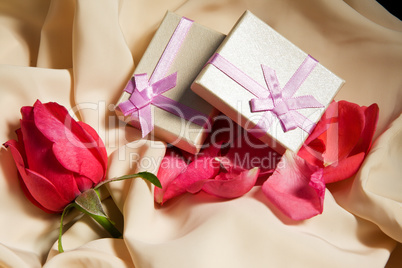 Gift Boxes over satin with rose arrangement.
