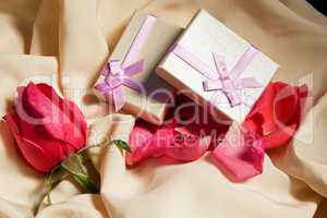 Gift Boxes over satin with rose arrangement.