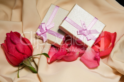 Gift Boxes over satin with rose arrangement.