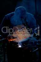 Man welding with reflection of sparks on visor