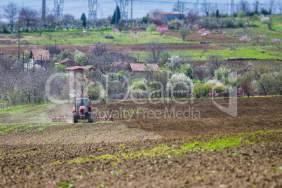 Brand new red tractor on the field working on land