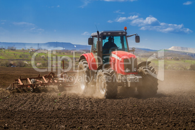 Brand new red tractor on the field working