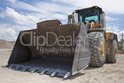 Yellow excavator on a construction site against blue sky