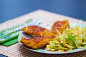 Breaded chicken meat with green salad