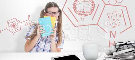 Composite image of geeky hipster hiding her face behind notepad