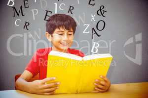 Composite image of cute boy reading book in library