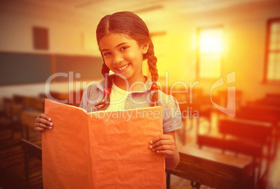 Composite image of cute pupil smiling at camera during class pre