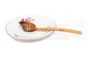 Plate and old spoon isolated on white