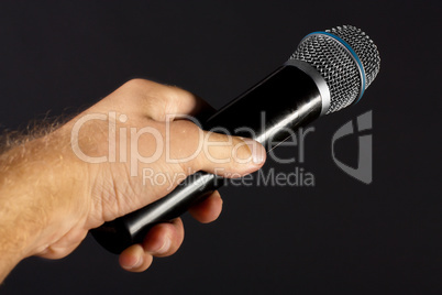 Classic microphone in performer hand isolated on black background