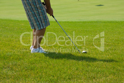 Golf player on a green course and hole