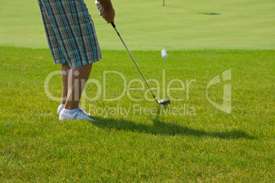 Golf player on a green course and hole