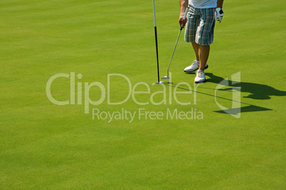 Golf player on a green course and hole