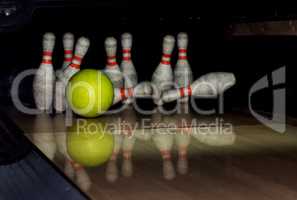 Bowling ball strike pins in front of dark background