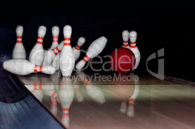 Bowling ball strike pins in front of dark background