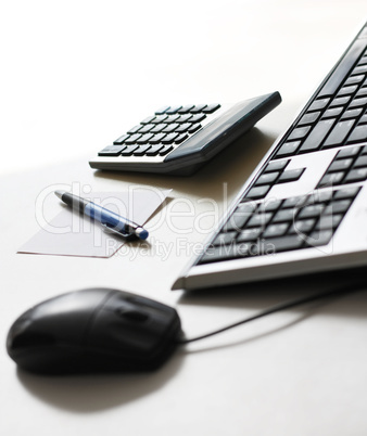 Working place with keyboard, mouse, calculator and pen