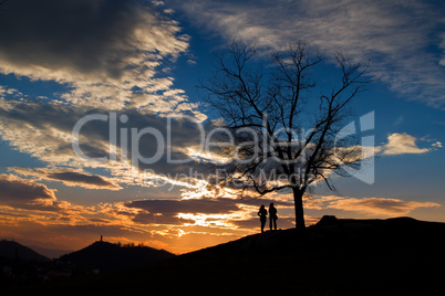 Silhouettes of people on sunset sky