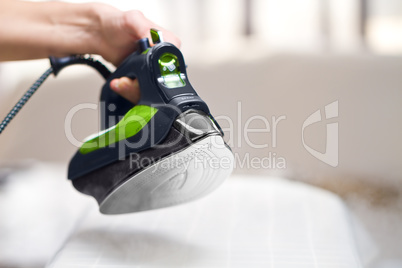 Woman ironing laundry with new ecologycal iron