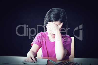 Composite image of cute pupil working at her desk