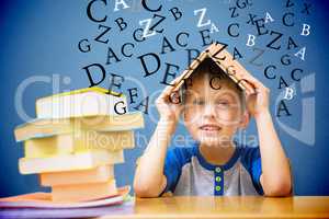 Composite image of cute boy with book on head