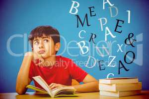 Composite image of thoughtful boy reading book in library