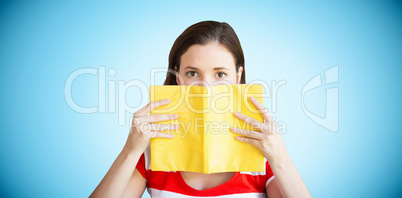 Composite image of student covering face with book in library