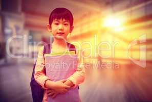 Composite image of cute pupil looking at camera holding notepad