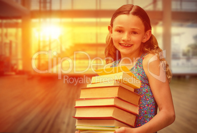 Composite image of cute little girl carrying books in library