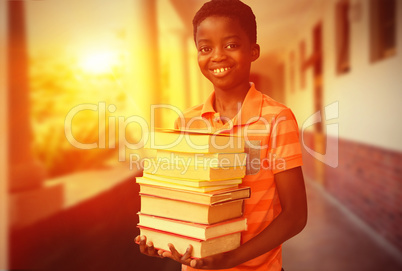 Composite image of portrait of cute boy carrying books in librar