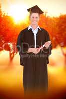Composite image of a male graduate with his degree in hand