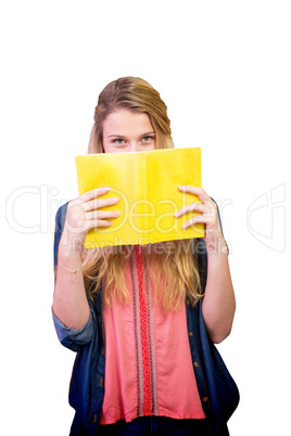 Composite image of student covering face with book in library