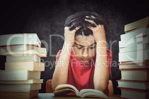 Composite image of tensed boy sitting with stack of books