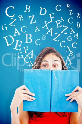 Composite image of portrait of a student hiding behind a blue bo