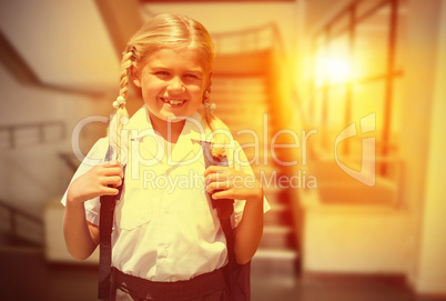 Composite image of cute pupil smiling at camera by the school bu