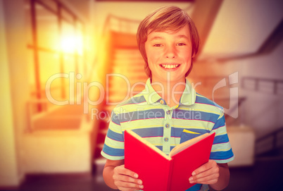 Composite image of cute pupil smiling at camera in library