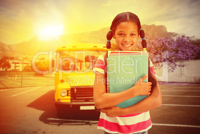 Composite image of cute pupil smiling at camera in library