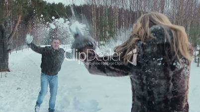 Young couple having snowball fight and kiss