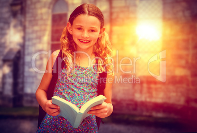 Composite image of cute little girl reading book in library